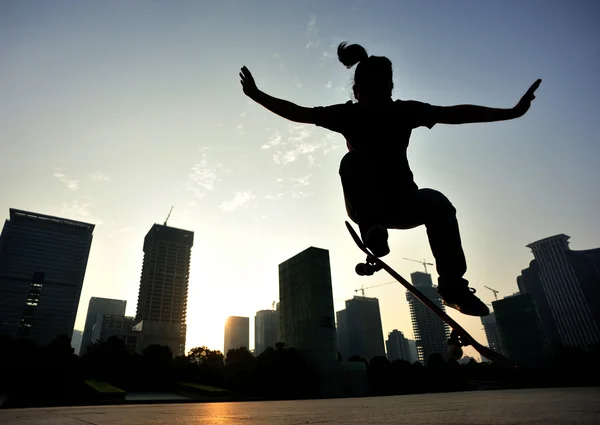 Skateboardåkare skateboard vid soluppgången stad — Stockfoto
