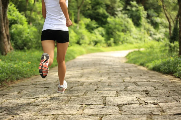 Jeune femme de remise en forme courir au sentier forestier — Photo