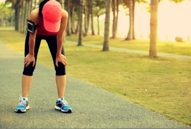 Tropikal park iz zor çalıştırdıktan sonra bir dinlenme alarak yorgun kadın runner