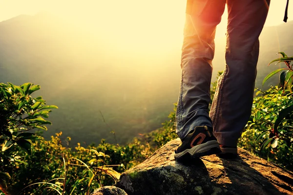 Ноги женщины-туриста стоят на вершине горы — стоковое фото