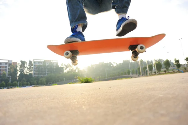 Skateboarder skateboarding při východu slunce města — Stock fotografie