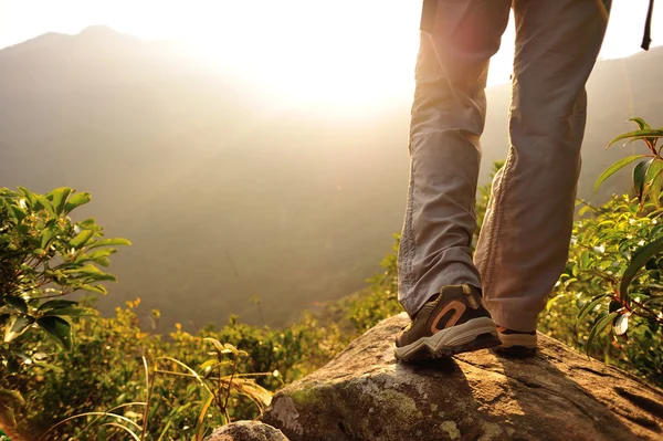 Woman hiker legs stand on mountain peak rock — Stock Photo, Image