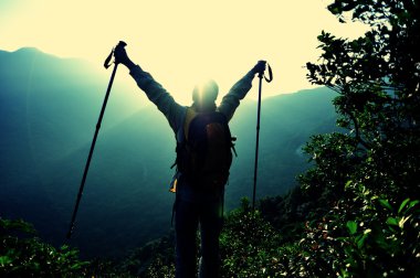 Tezahüratçı kadın dağların zirvesinde kollarını açtı.