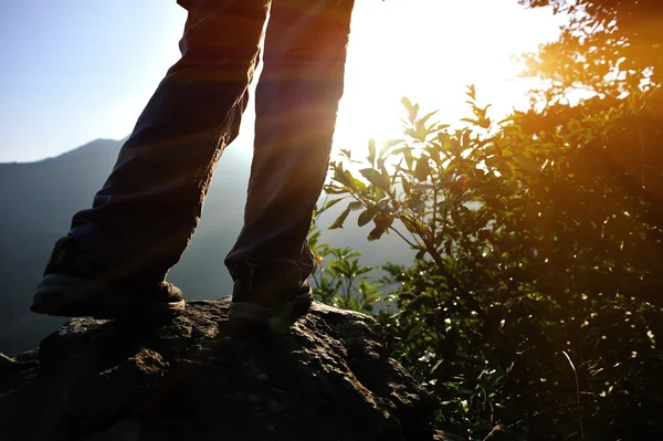 Kvinnan hiker benen stå på mountain peak rock — Stockfoto