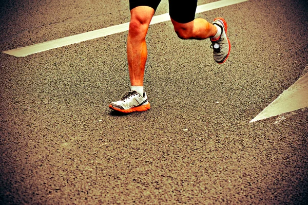 Марафонские легкоатлеты бегают по городской дороге — стоковое фото