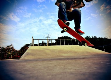 Skateboarder skateboarding at skatepark clipart