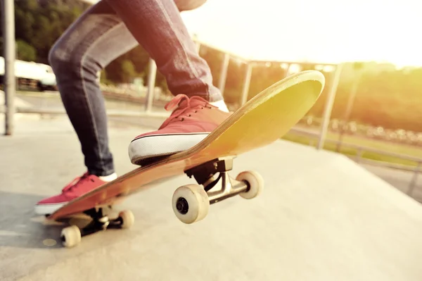 在滑板滑板的年轻女子双腿 — 图库照片