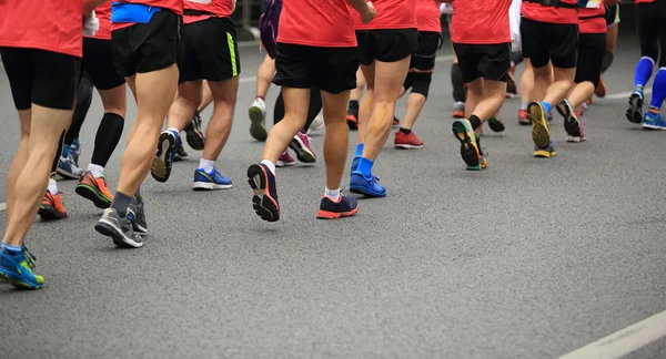 Gambe non identificate degli atleti della maratona che corrono sulla strada cittadina — Foto Stock