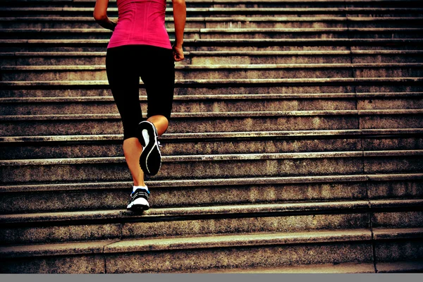 Спортивная женщина бежит по каменной лестнице — стоковое фото
