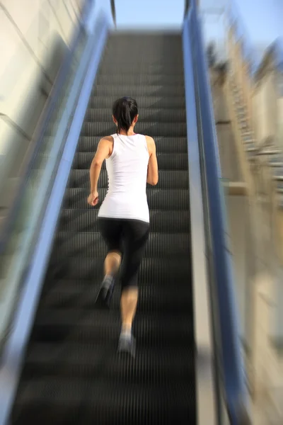 Löpare idrottsman körs på rulltrappa trappor. kvinna fitness jogging träning wellness koncept. — Stockfoto