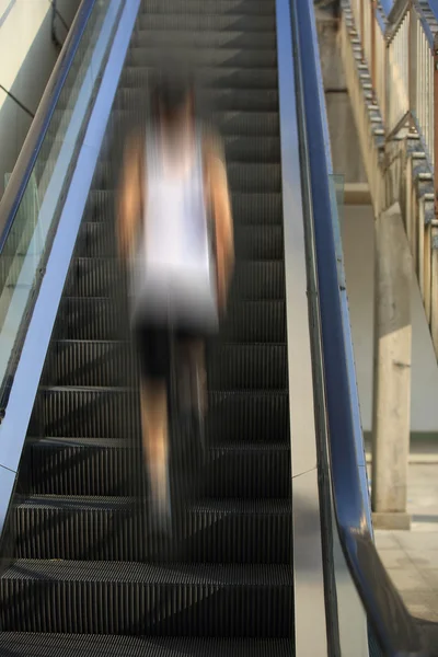 跑步运动员在自动扶梯楼梯上运行。女人健身慢跑锻炼健康概念. — 图库照片