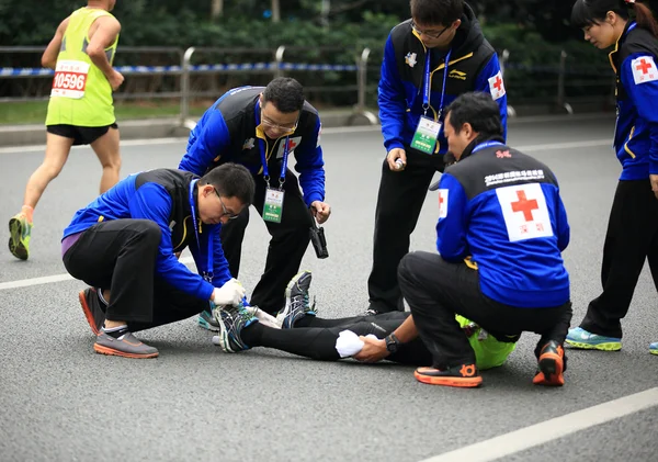 El apoyo médico ayuda a un corredor de maratón lesionado — Foto de Stock