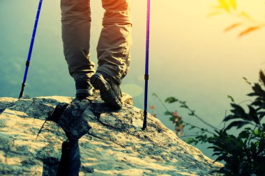 Kadın uzun yürüyüşe çıkan kimse bacaklar dağ en yüksek kayanın üzerinde durun