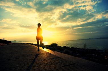 Deniz kenarında çalışan runner atlet. kadın fitness siluet gündoğumu koşu egzersiz sağlık kavramı.