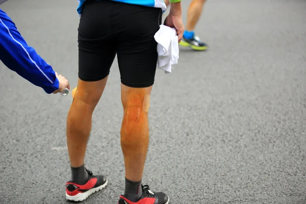 医療支援は、マラソン ランナーの脚の噴霧 — ストック写真