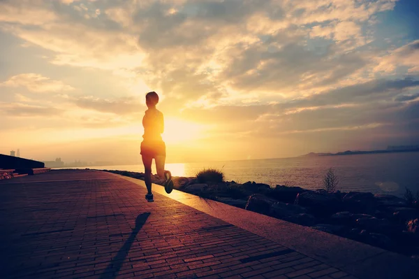 Atleta corridore che corre al mare. donna fitness silhouette alba jogging allenamento concetto di benessere . — Foto Stock