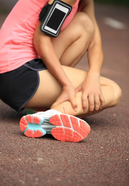 Woman runner hold her twisted ankle — Stock Photo, Image