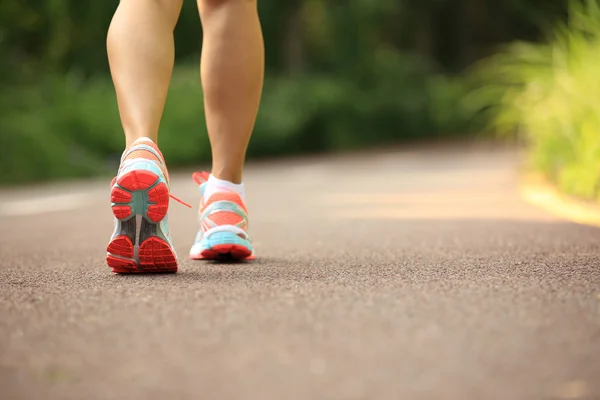 Joven fitness piernas de mujer corriendo en el camino del bosque — Foto de Stock