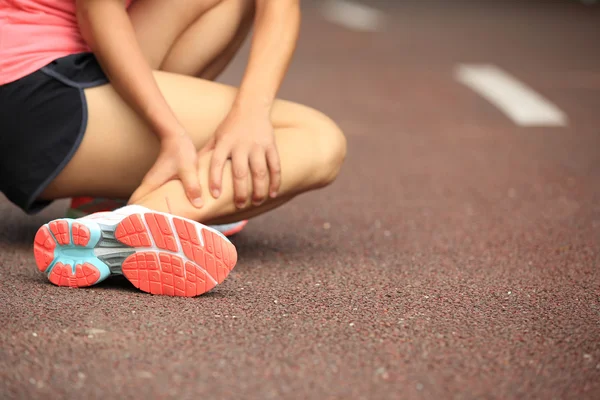 Woman runner hold her twisted ankle — Stock Photo, Image