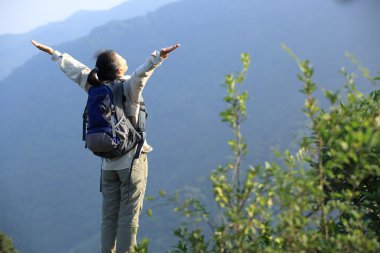 Tezahüratçı kadın dağların zirvesinde kollarını açtı.