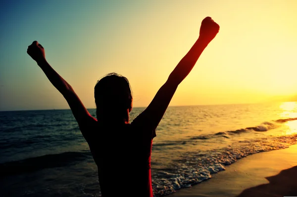 Cheering donna braccia aperte al tramonto spiaggia sul mare — Foto Stock