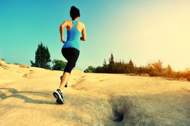 Sahil dağ iz üzerinde çalışan genç kadın runner bacaklar