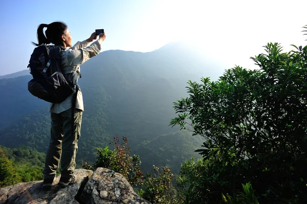 在山顶的智能手机上的徒步旅行者 — 图库照片