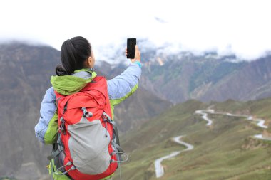 Uzun yürüyüşe çıkan kimse smartphone ile dağ üst