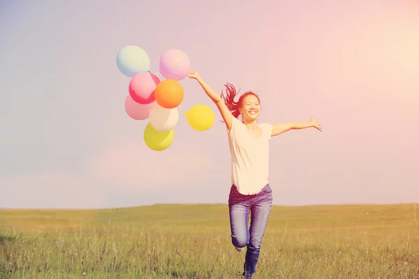 Asian woman on running with balloons — Stock Photo, Image