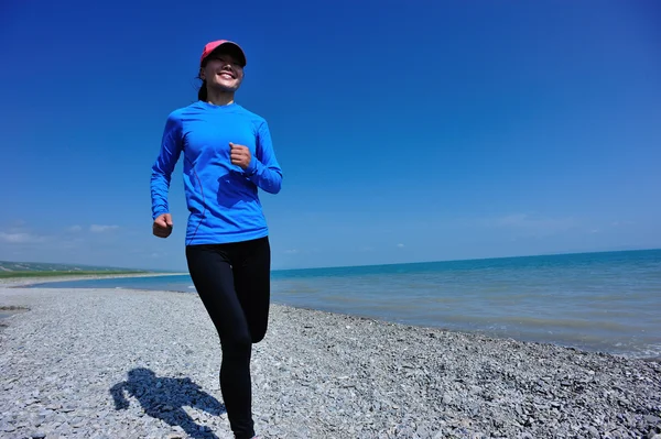 Mujer corriendo en la playa de piedra —  Fotos de Stock