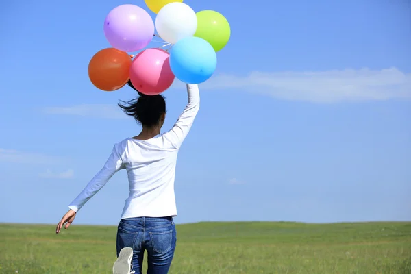 Mujer corriendo con globos de colores —  Fotos de Stock