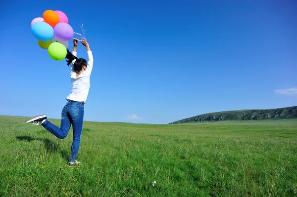 Kvinnan kör med färgade ballonger — Stockfoto