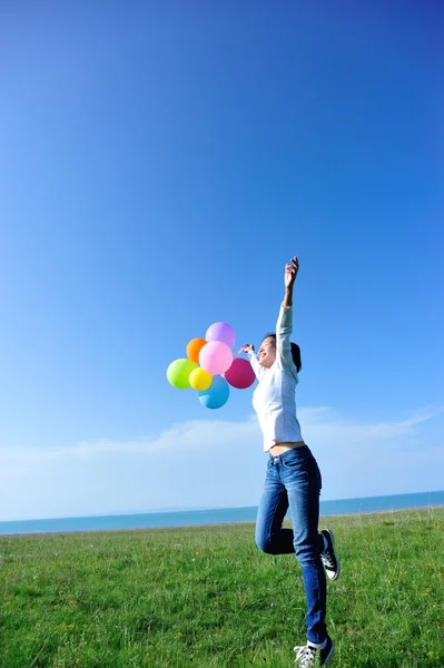 Femme sautant avec des ballons — Photo