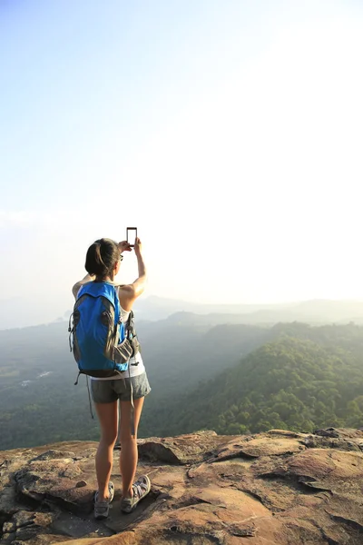 Senderista en la cima de la montaña con smartphone — Foto de Stock