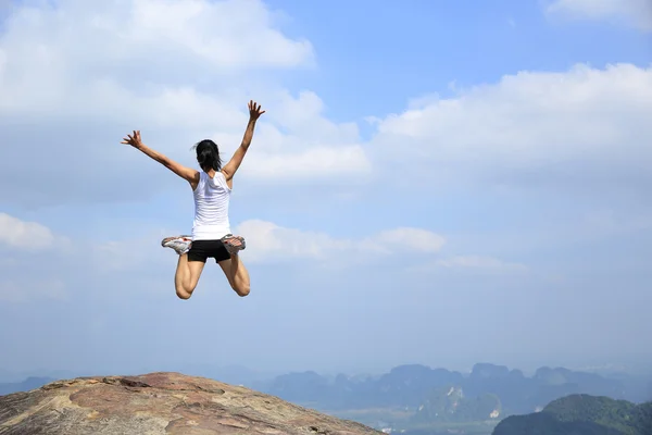 Lycklig kvinna hoppa över blå himmel — Stockfoto