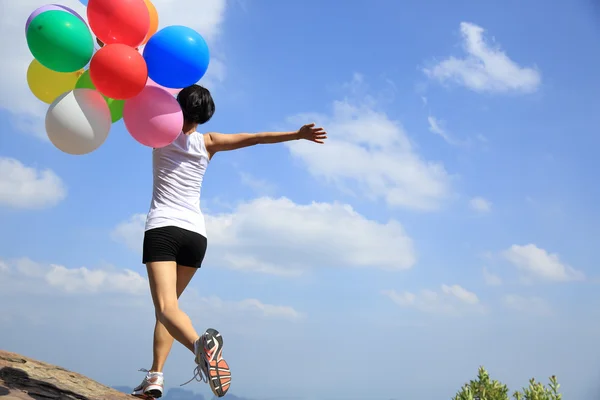 Asian woman on mountain with balloons — Stock Photo, Image