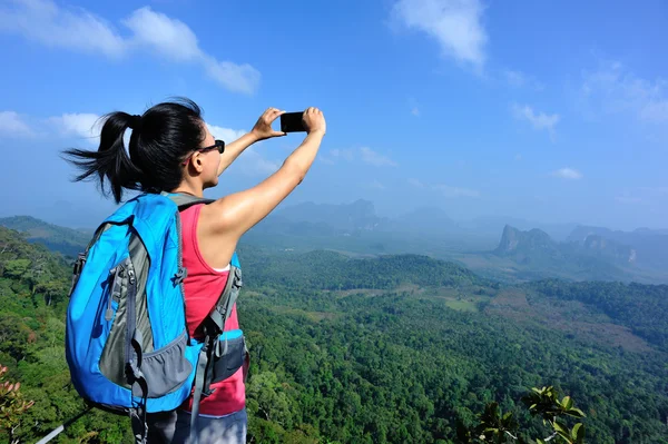 Senderista en la cima de la montaña con smartphone — Foto de Stock