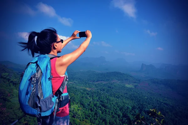 Turista na vrchol hory s smartphone — Stock fotografie