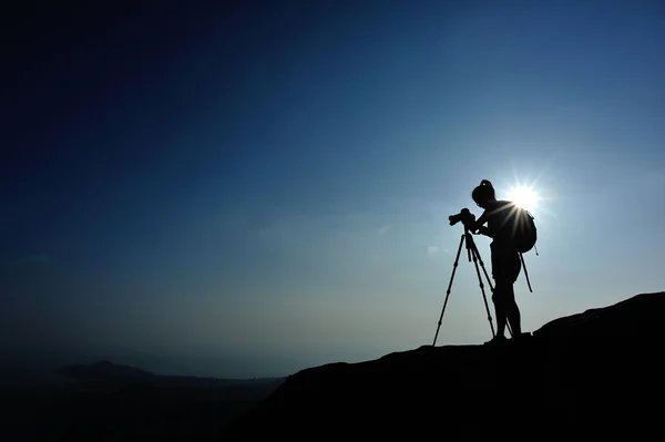 Femme photographe sur le pic de montagne coucher de soleil — Photo