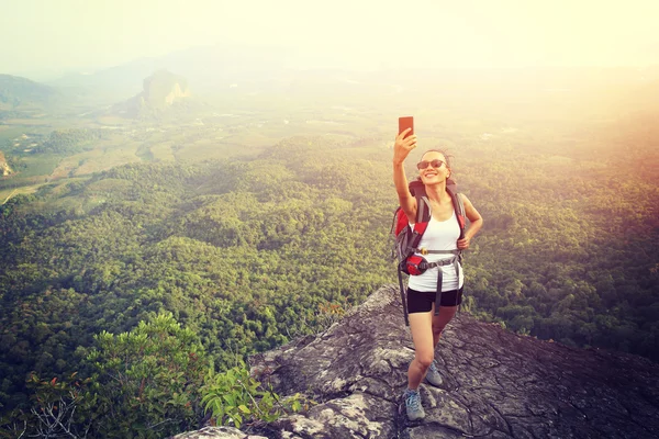 Турист на вершине горы со смартфоном — стоковое фото