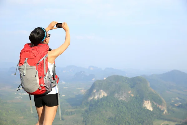 Escursionista in cima alla montagna con smartphone — Foto Stock