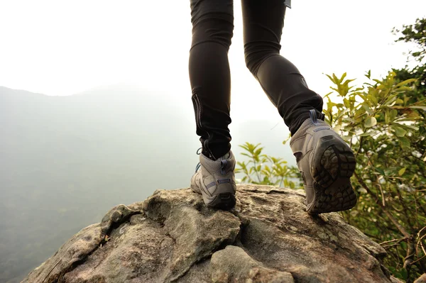 Piernas femeninas en la cima de la montaña — Foto de Stock