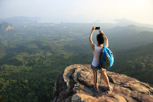 Hiker on mountain top with smartphone — Stock Photo, Image