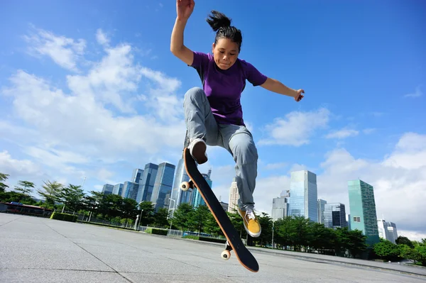 Frau springt auf Skateboard — Stockfoto