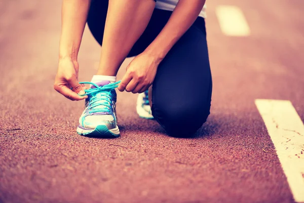 Mujer corredora atando cordones — Foto de Stock