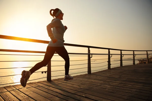 Kobieta jogging o wschodzie słońca — Zdjęcie stockowe