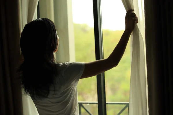 Woman opening curtains — Stock Photo, Image