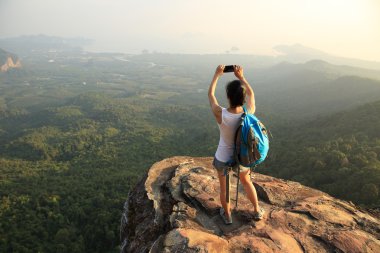 Uzun yürüyüşe çıkan kimse smartphone ile dağ üst