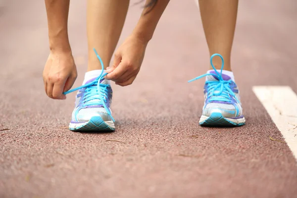 Mujer corredora atando cordones — Foto de Stock