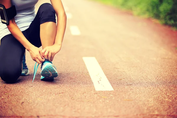 Mujer corredora atando cordones — Foto de Stock